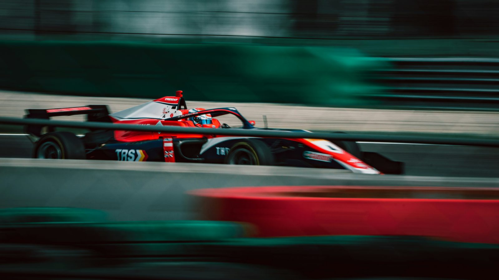 A Formula car at racing speed, panned against a blurred background, conveying the cornering loads discussed in this article.